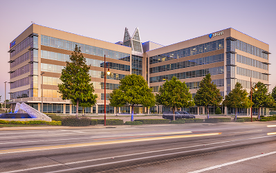10100 Multi-story office building at Greenside with a glass facade and young trees along the street
