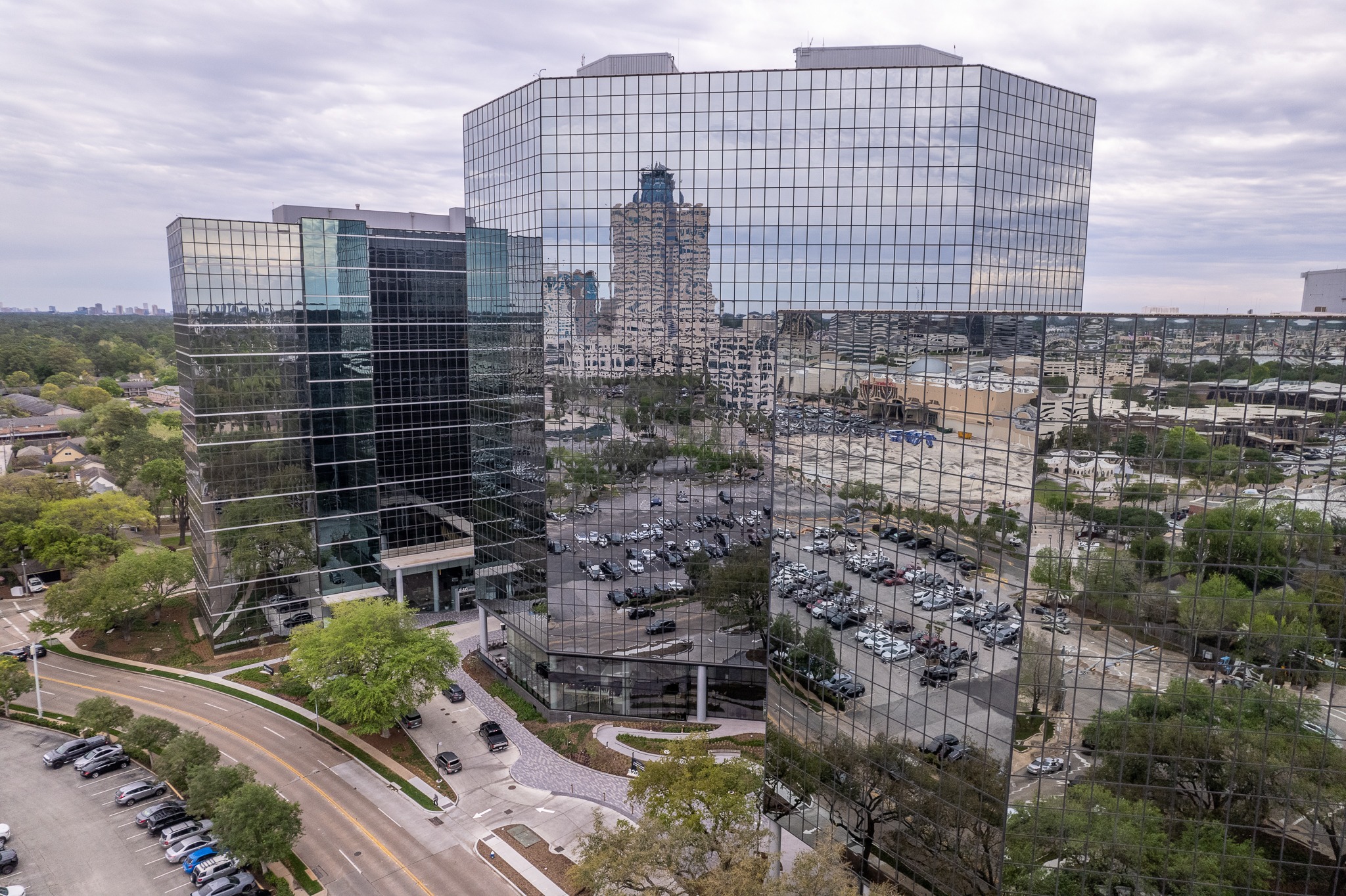 Aerial view of the dark mirrored-glass office tower at 820 Gessner Road