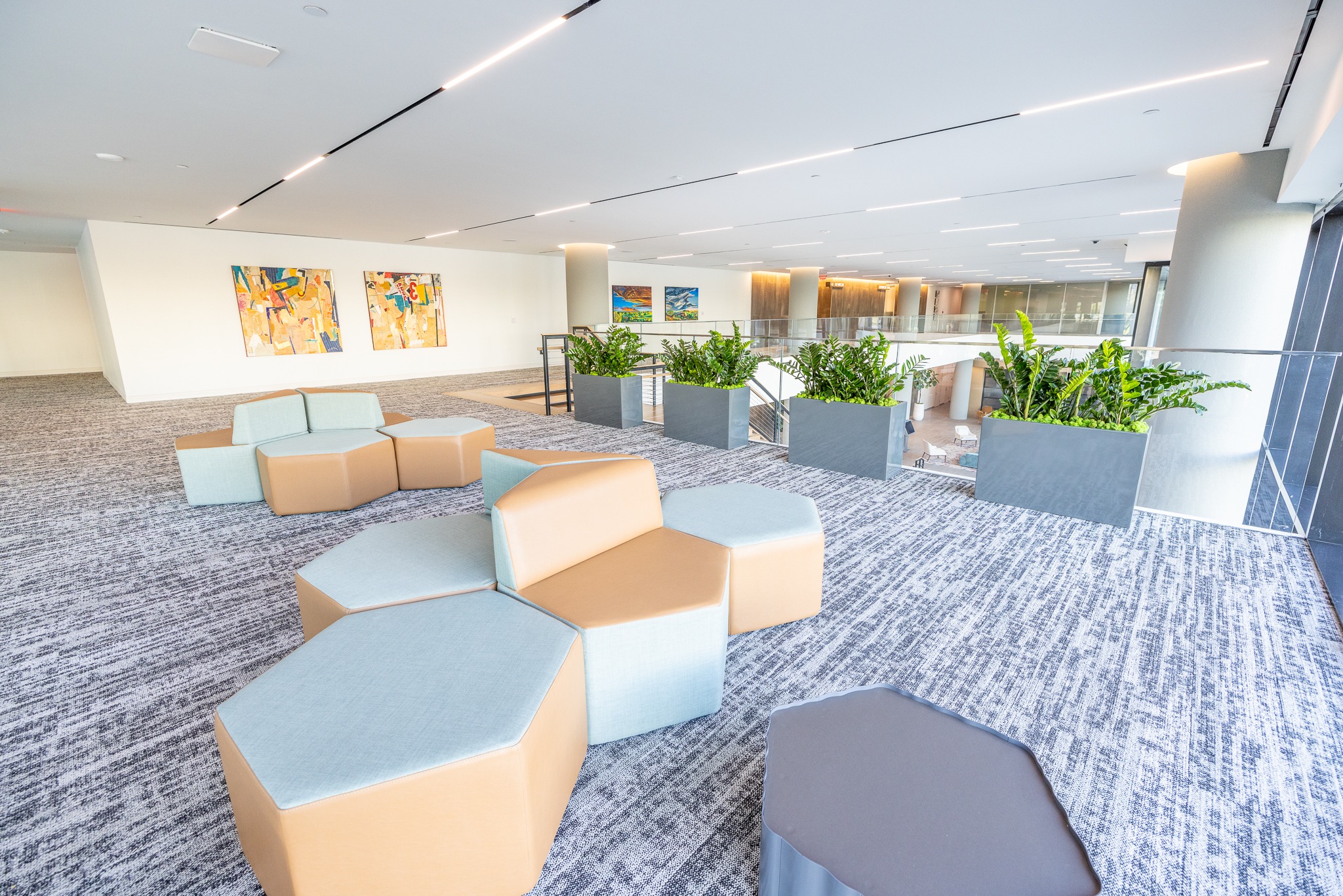 Lounge seating at 820 Gessner Road with blue and tan modular chairs and hexagonal tables