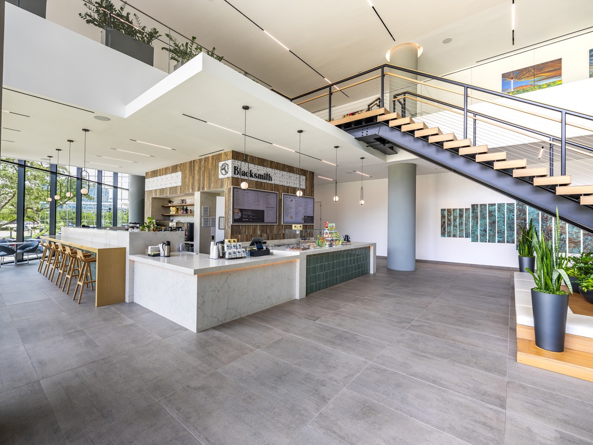 Cafe and pantry area at 820 Gessner Road with a service counter and a glass-railed staircase