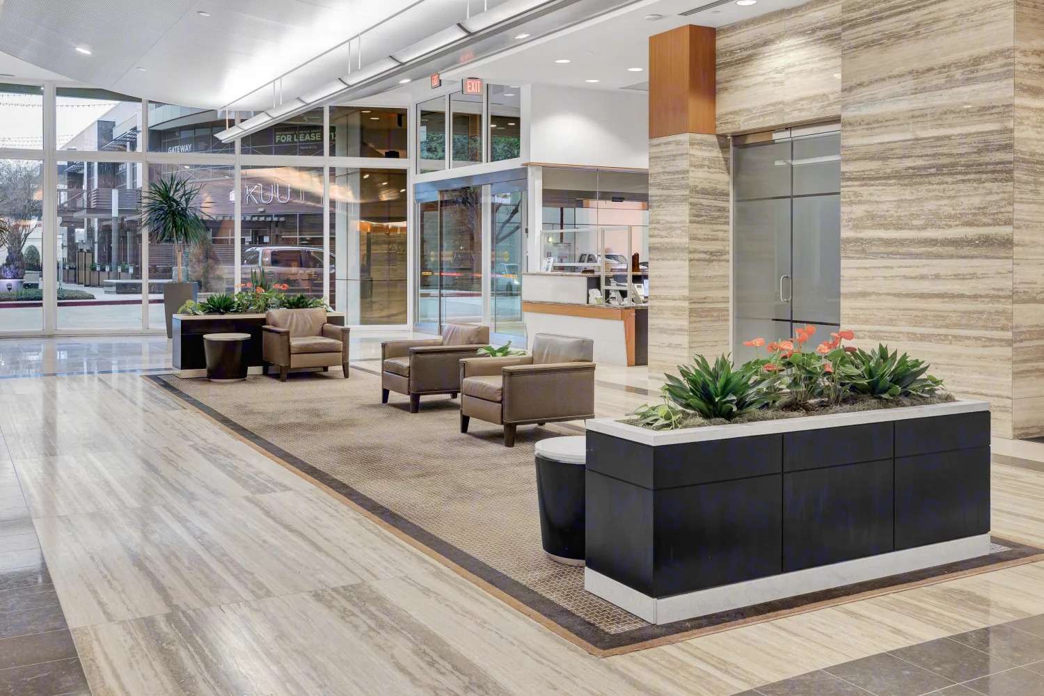 Lobby seating at 929 Gessner Road with planters and glass walls to the street