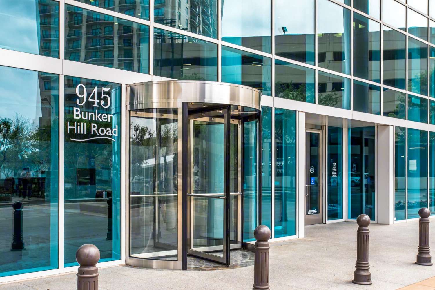 Revolving door entrance at 945 Bunker Hill Road with the address etched on the glass