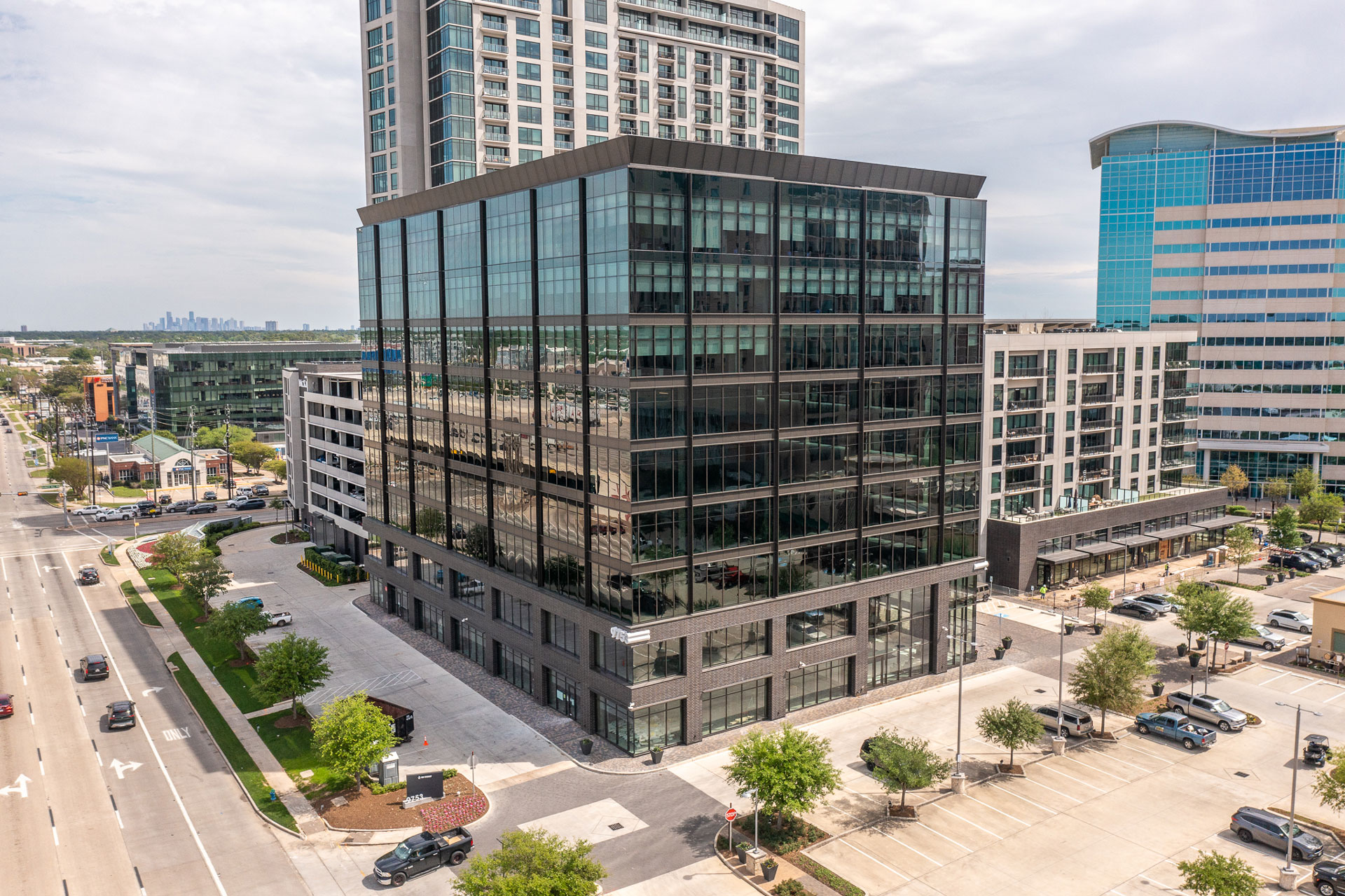 Aerial view of the office building at 9753 Katy Freeway with residential towers beyond