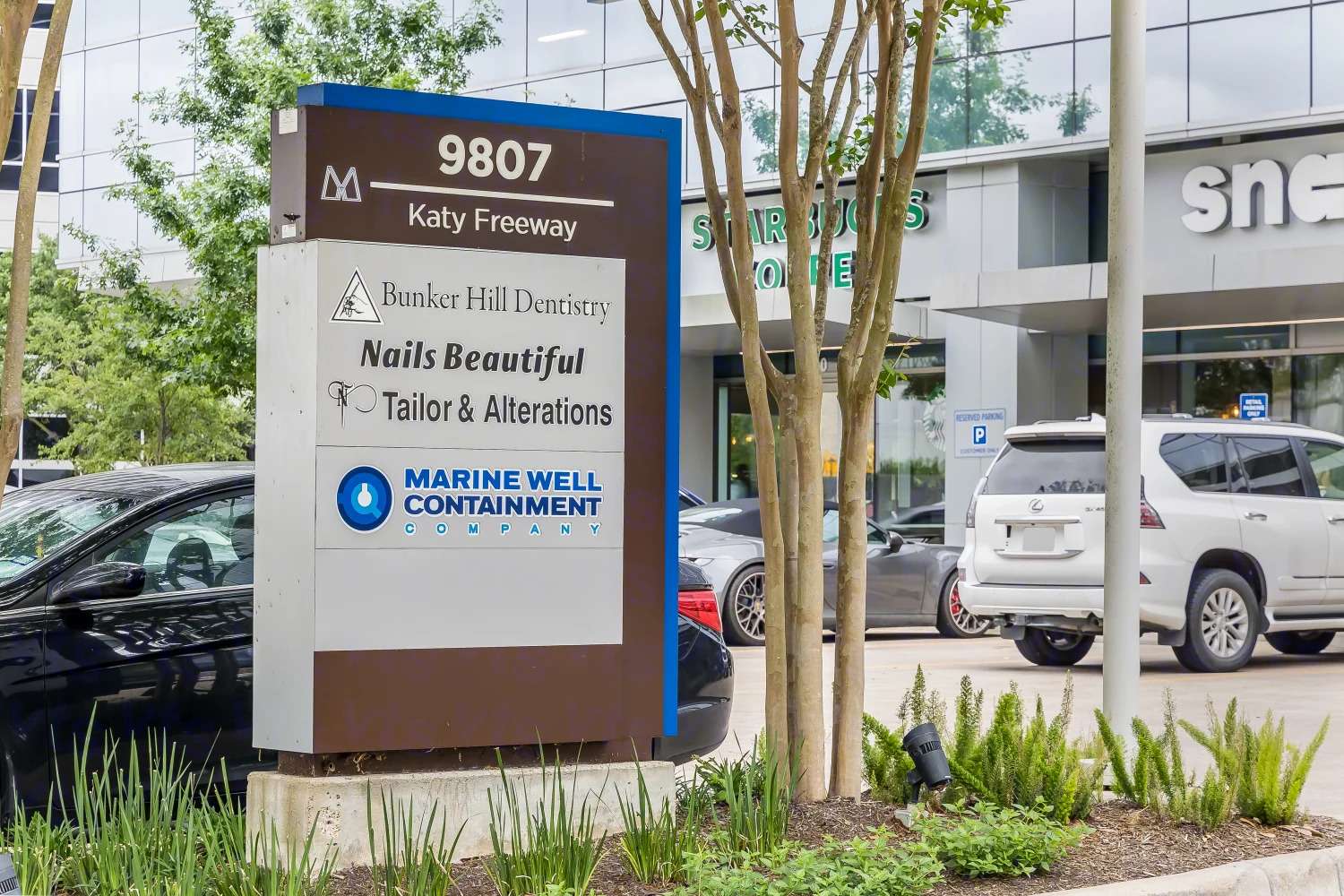 Monument sign at 9807 Katy Freeway listing tenants including Bunker Hill Cleaners, Nails Beautiful and Marine Well Containment