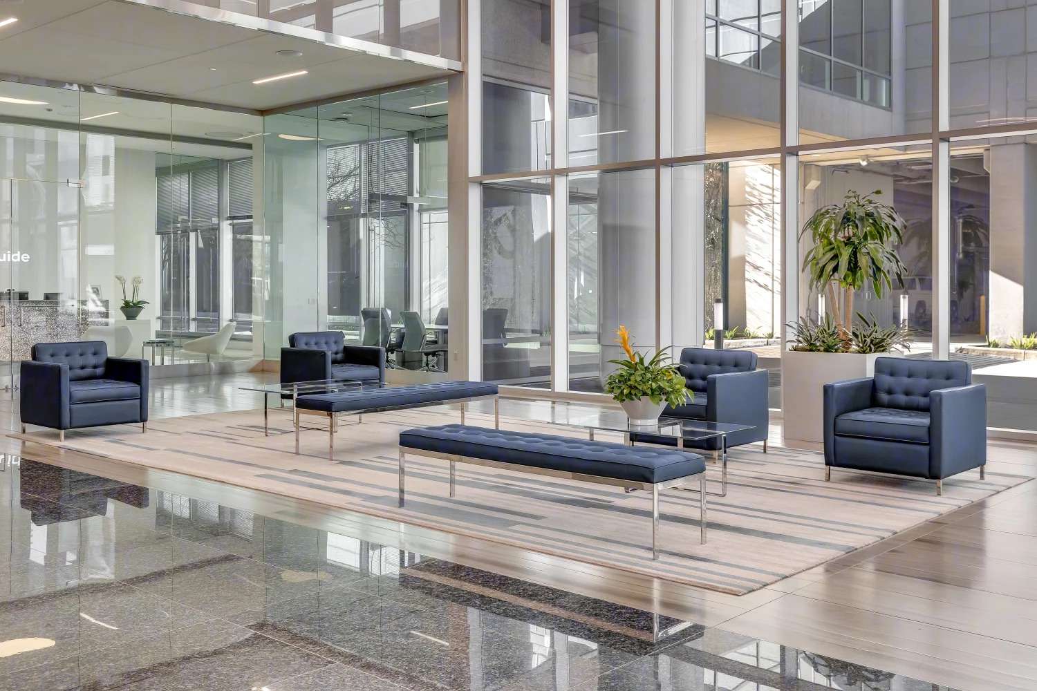 Lobby lounge at Air Liquide Center South with dark armchairs, a bench and glass walls
