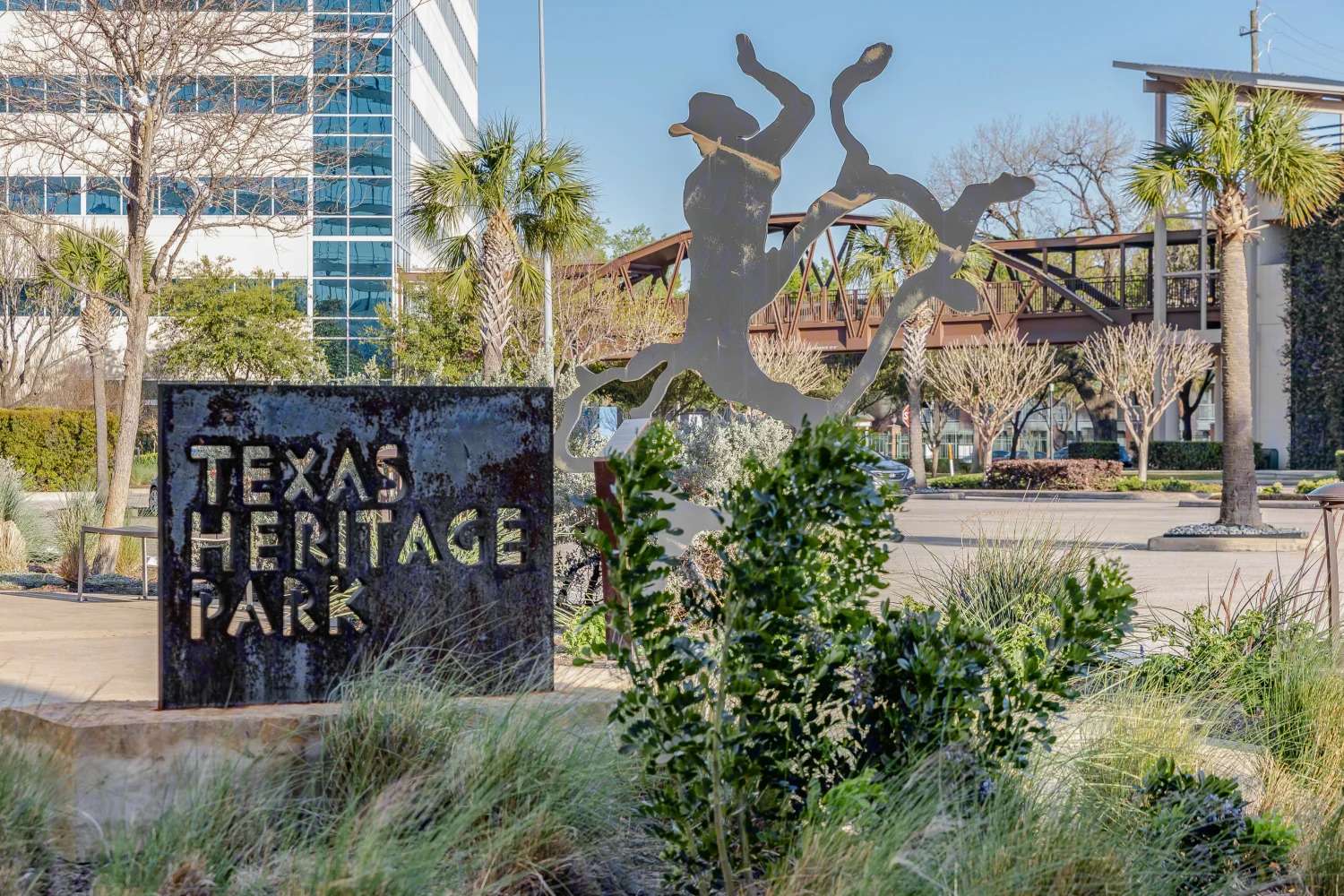 Texas Heritage Park sign among landscaping and sculptural artwork at 9811 Katy Freeway