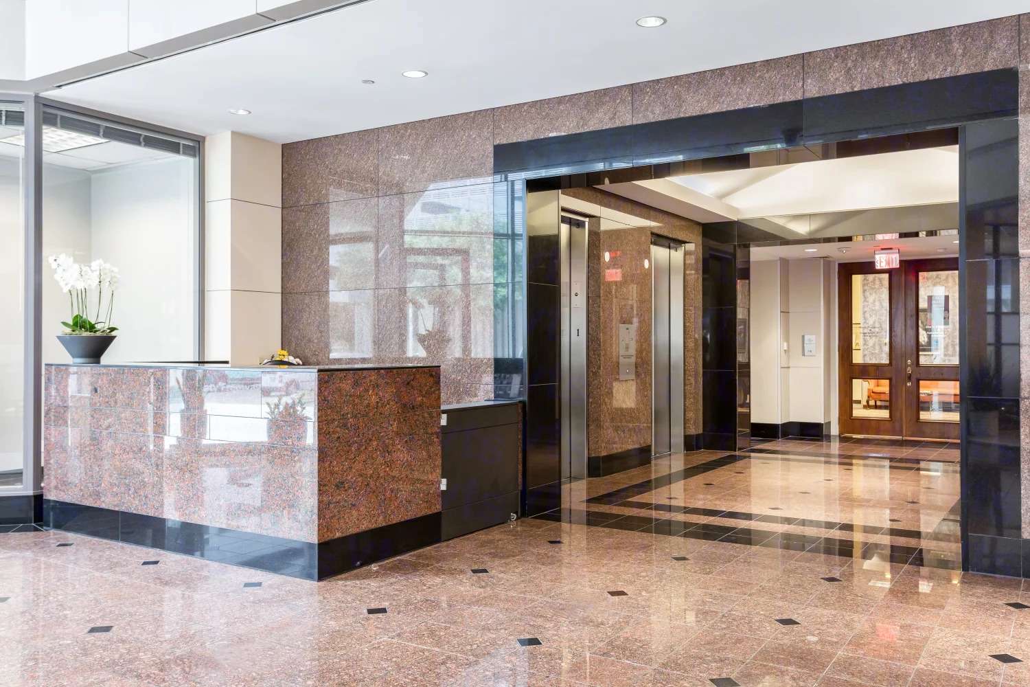 Elevator lobby at 9821 Katy Freeway with a stone reception counter and marble floors