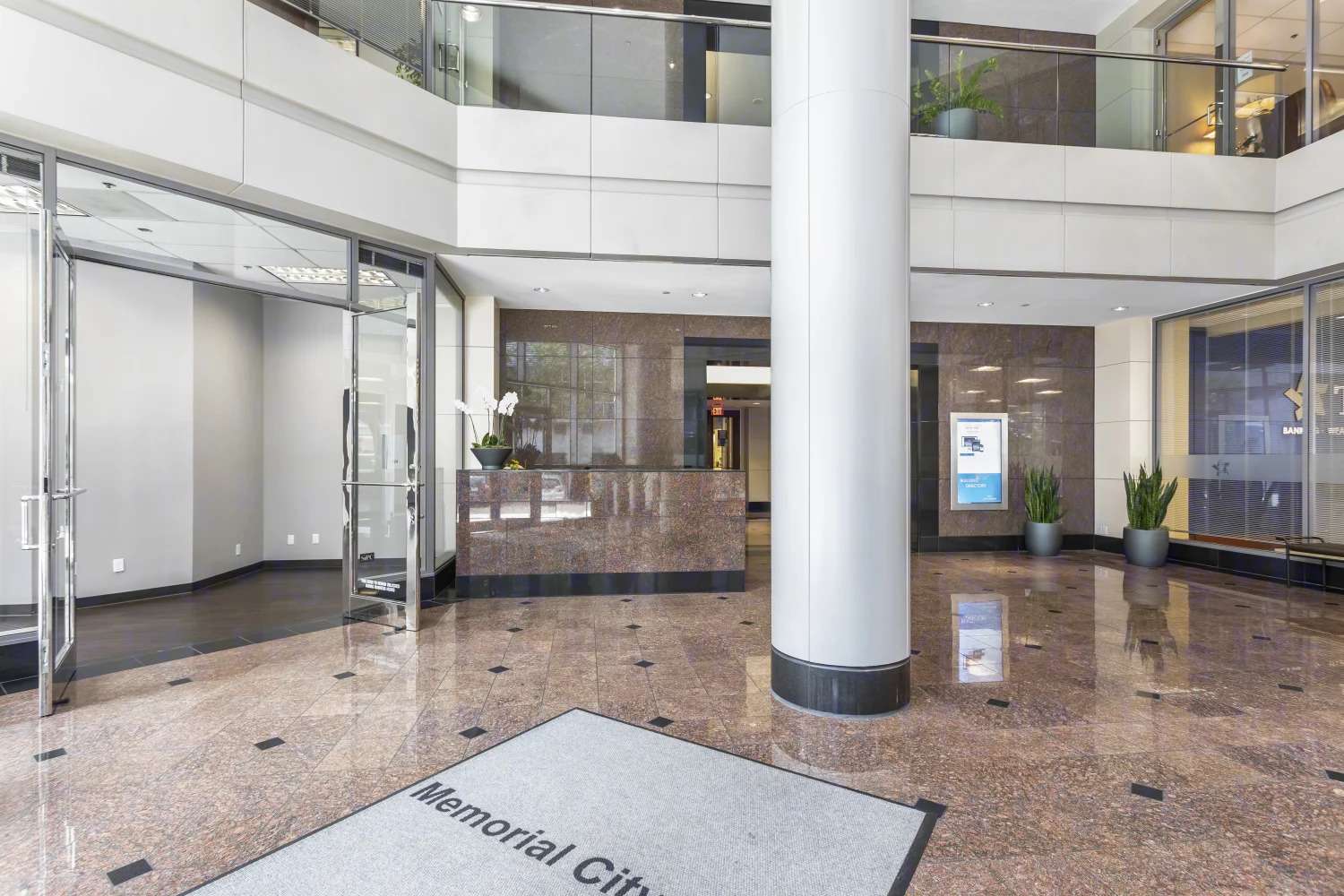 Lobby interior at 9821 Katy Freeway with columns, glass entry doors and a Memorial City floor mat