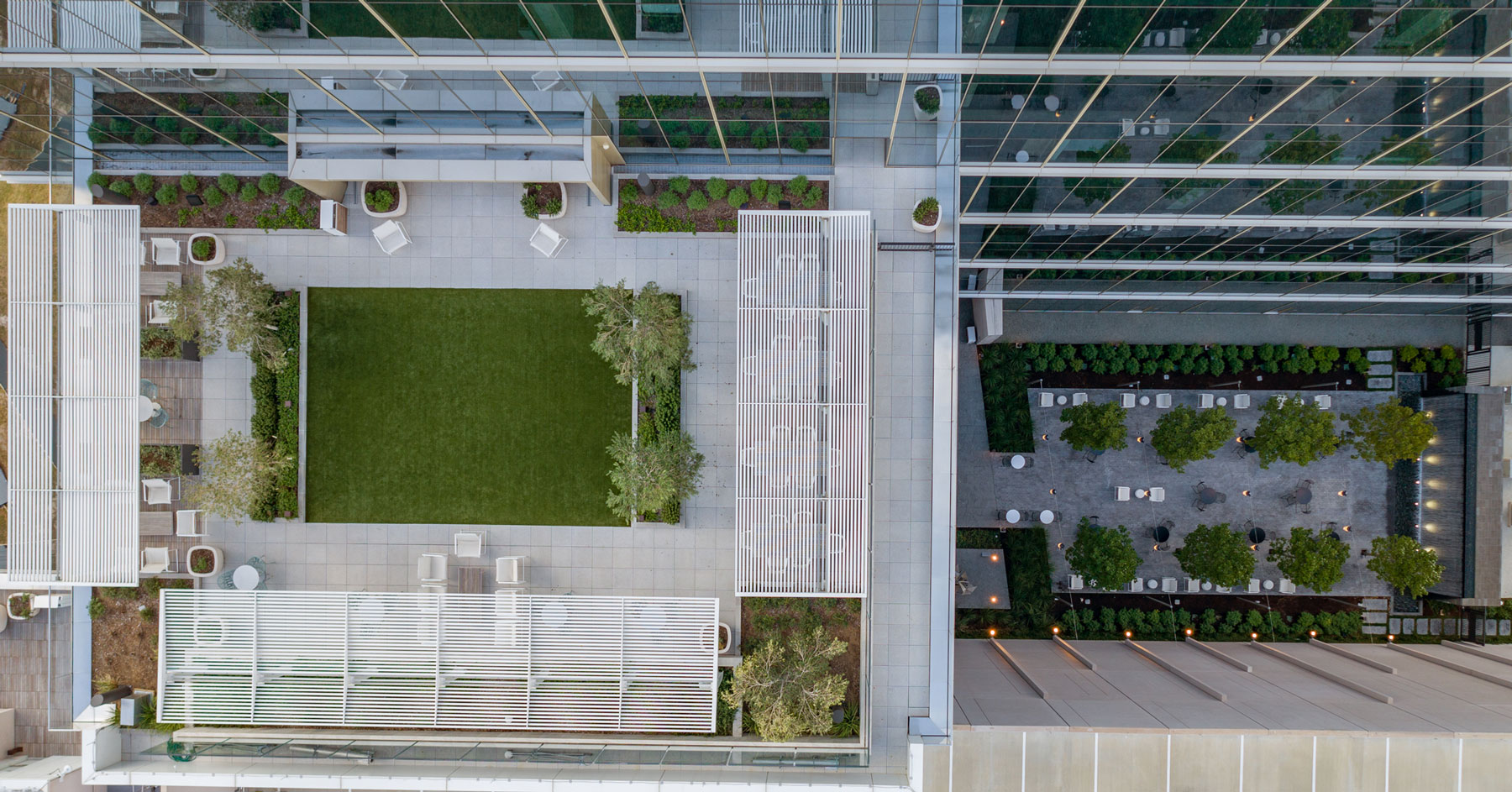 Overhead view of the landscaped terrace at 990 Town & Country with a lawn panel and pergola
