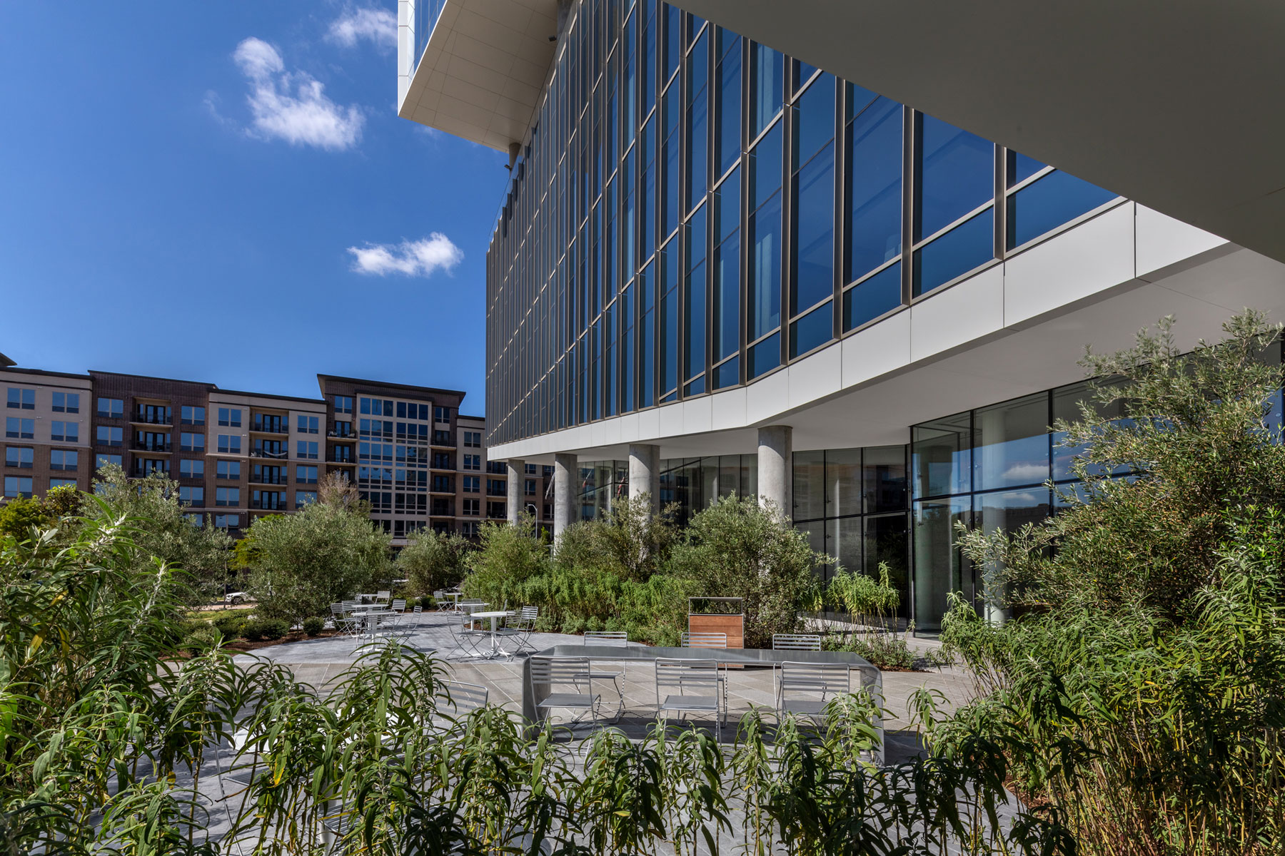 Exterior of the glass tower at 990 Town & Country with landscaping and neighbouring buildings