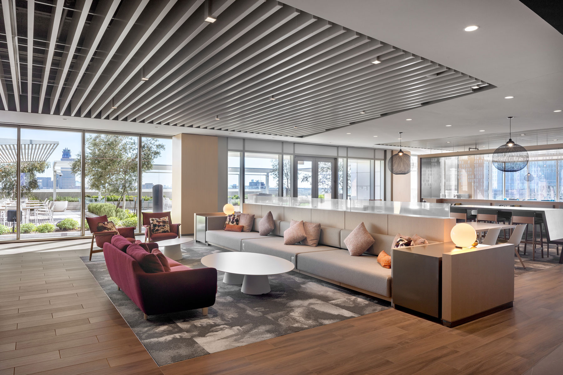Indoor lounge at 990 Town & Country with a curved sofa, red chairs and a slatted wood ceiling