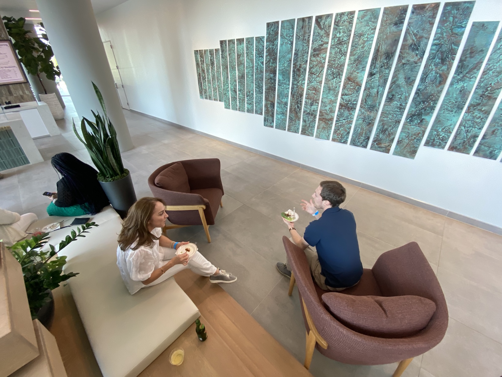 Lobby seating at Memorial City Plaza in front of a wall of vertical green art panels