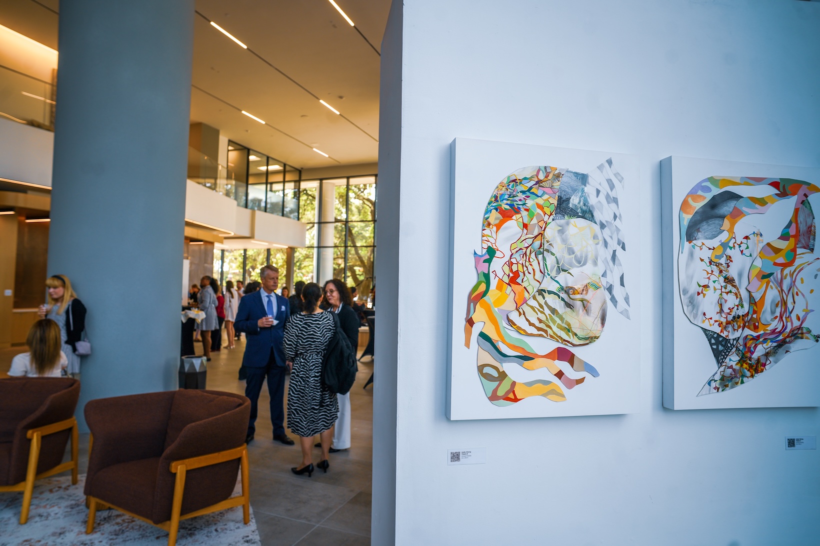 Guests at an event in the Memorial City Plaza lobby, beside colourful abstract artworks