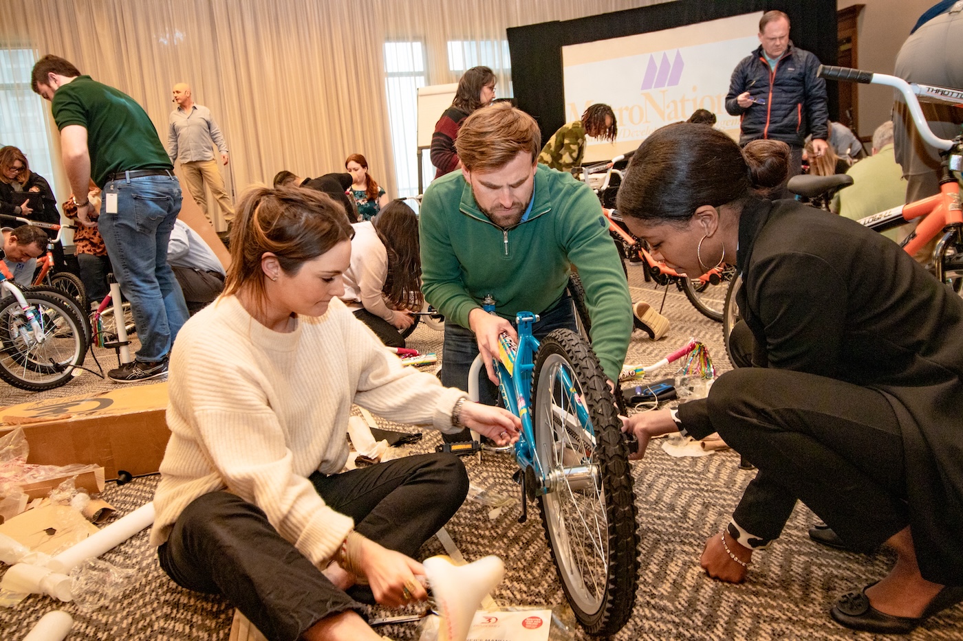 Volunteers assembling bicycles together at a MetroNational community event