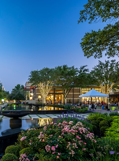 Landscaped canal at CityCentre at dusk, edged with flowering beds