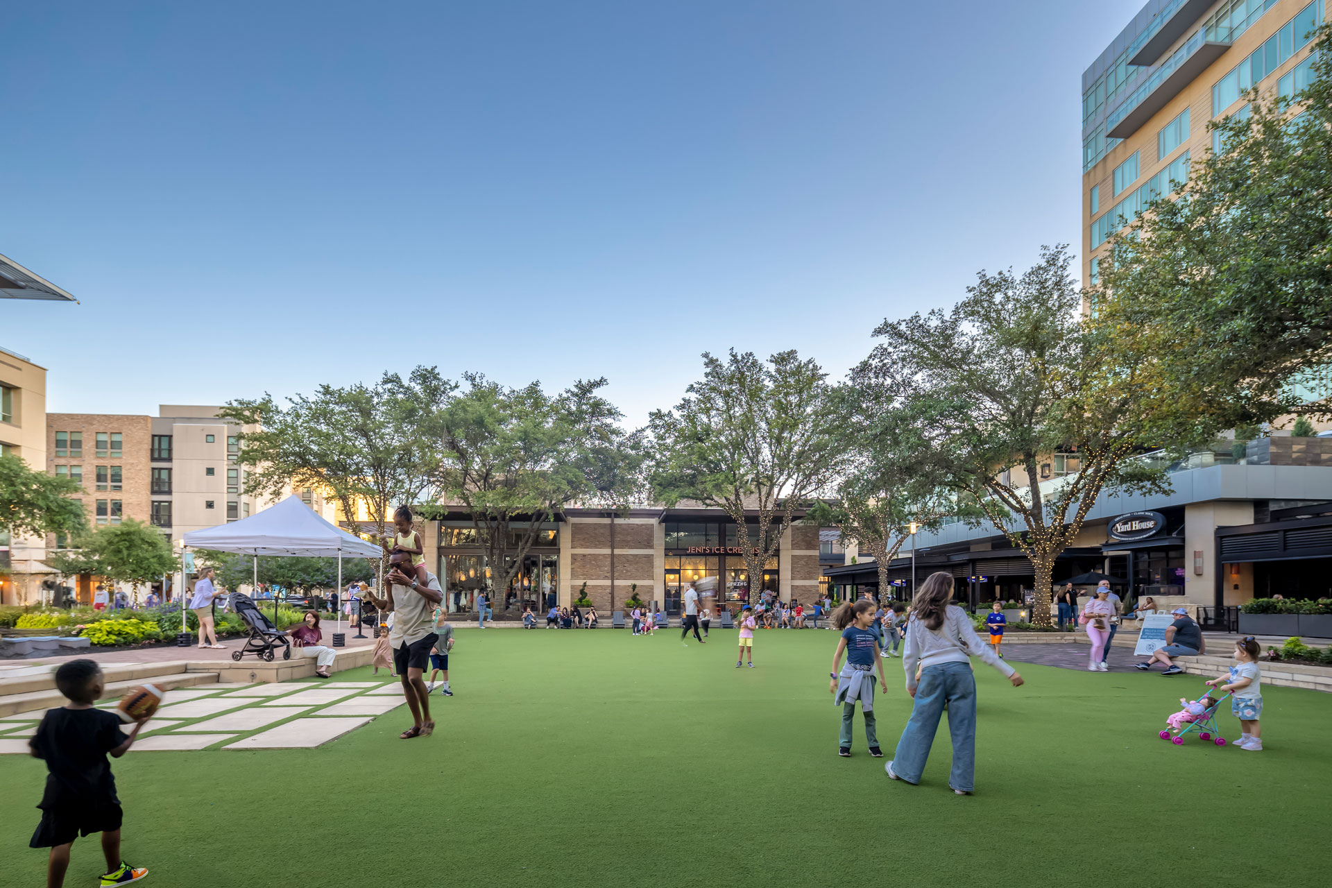 Families gathered on the central lawn at CityCentre, framed by the surrounding retail buildings