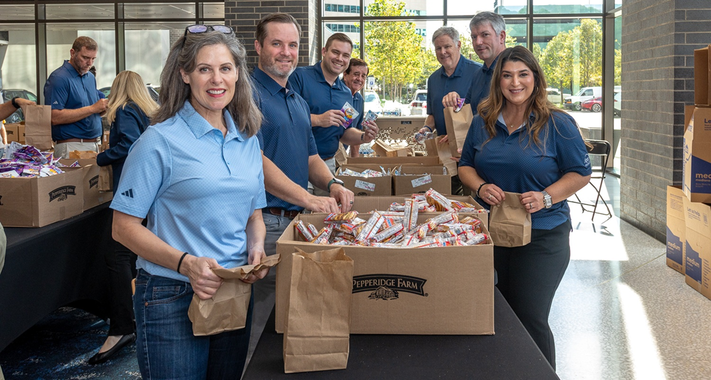 MetroNational employees packing food bags at a community service project