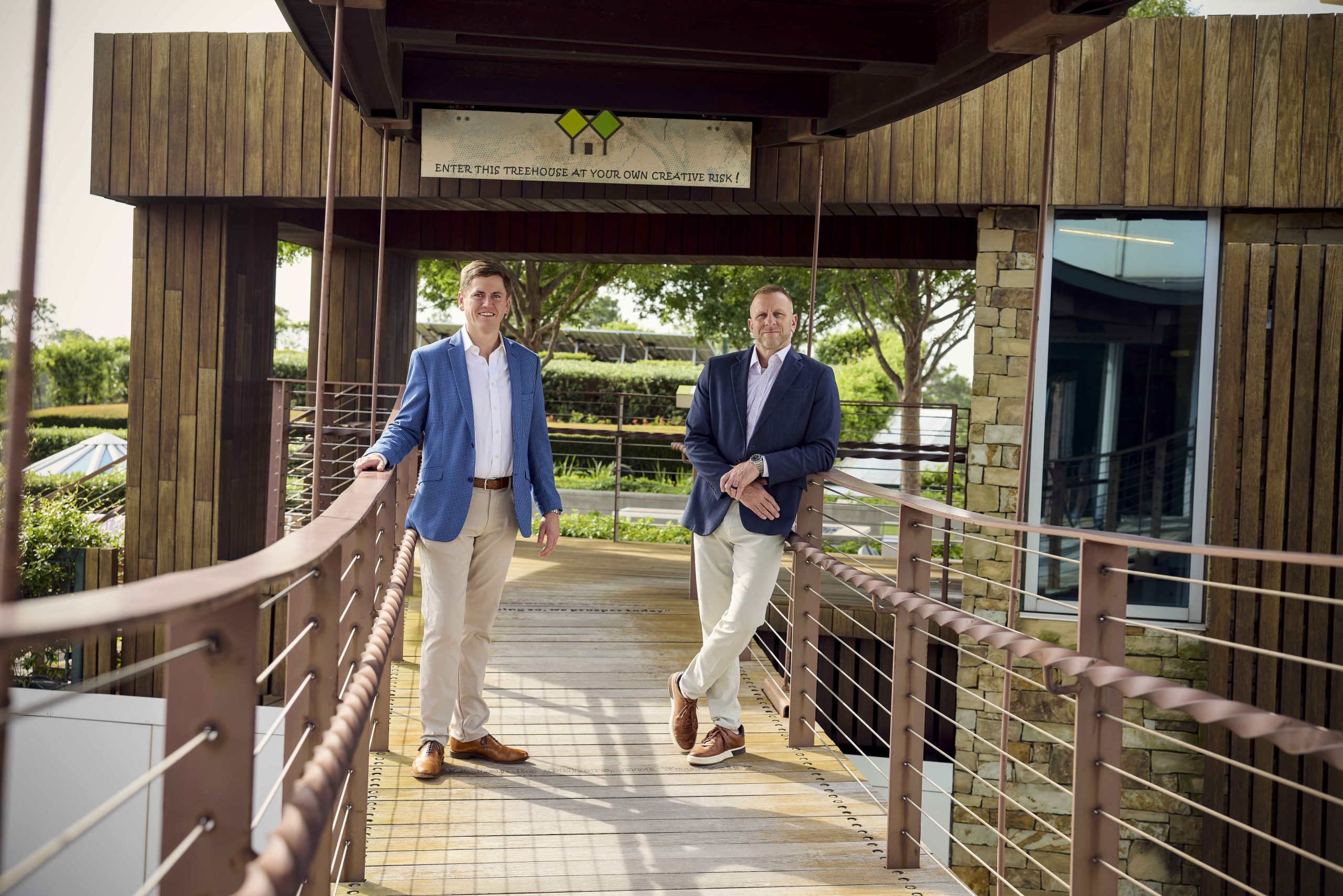 Two colleagues talking on a timber boardwalk outside a MetroNational property
