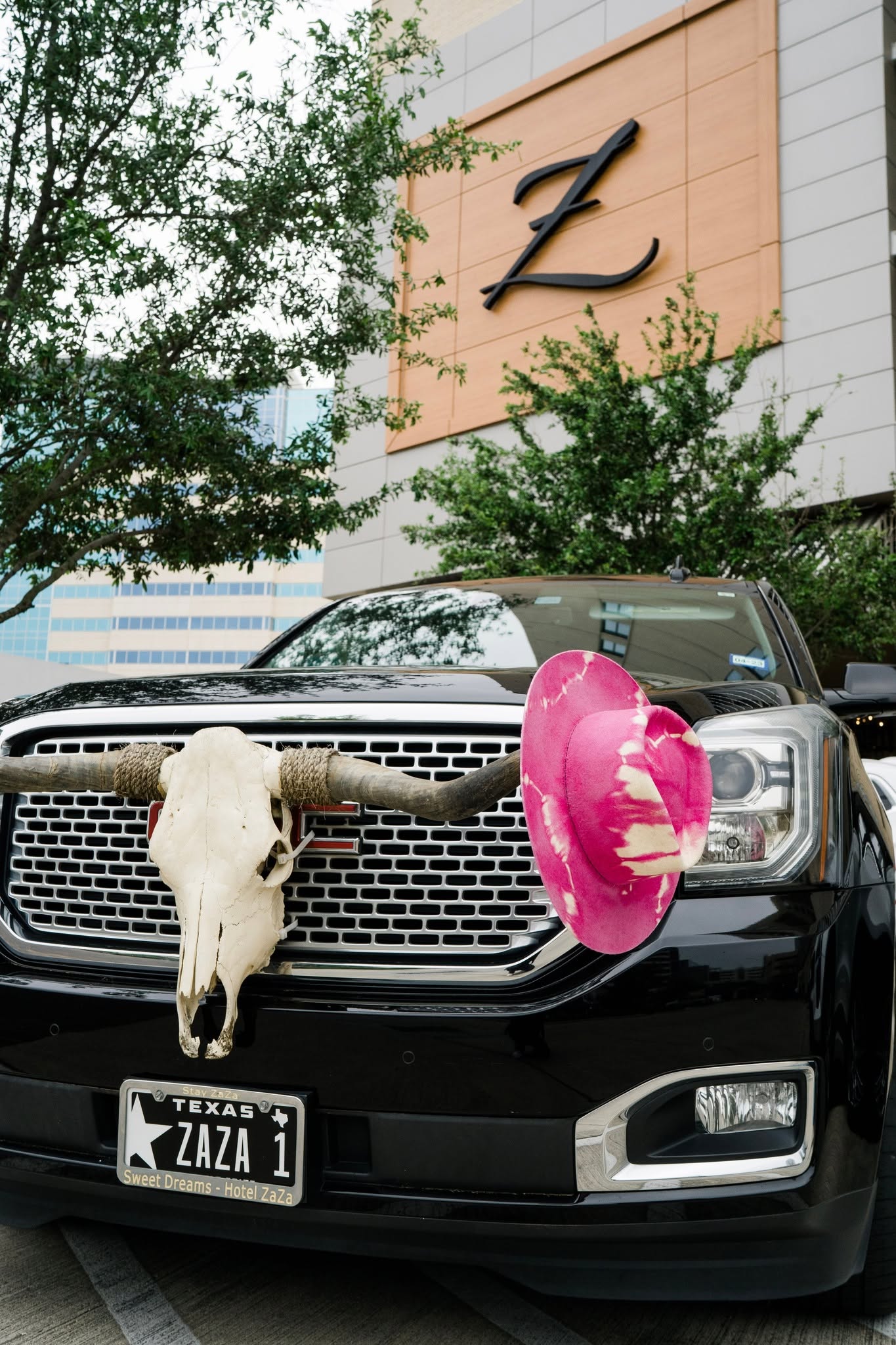 Black pickup truck at Hotel ZaZa Memorial with a Z sign and a pink pool float on the hood