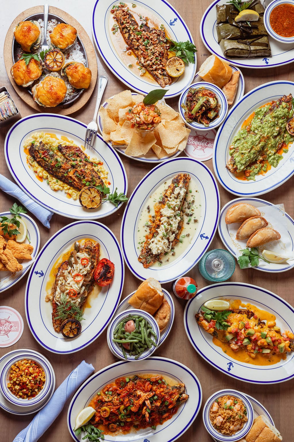 Overhead spread of seafood dishes in bowls and plates from Goode Co. Seafood