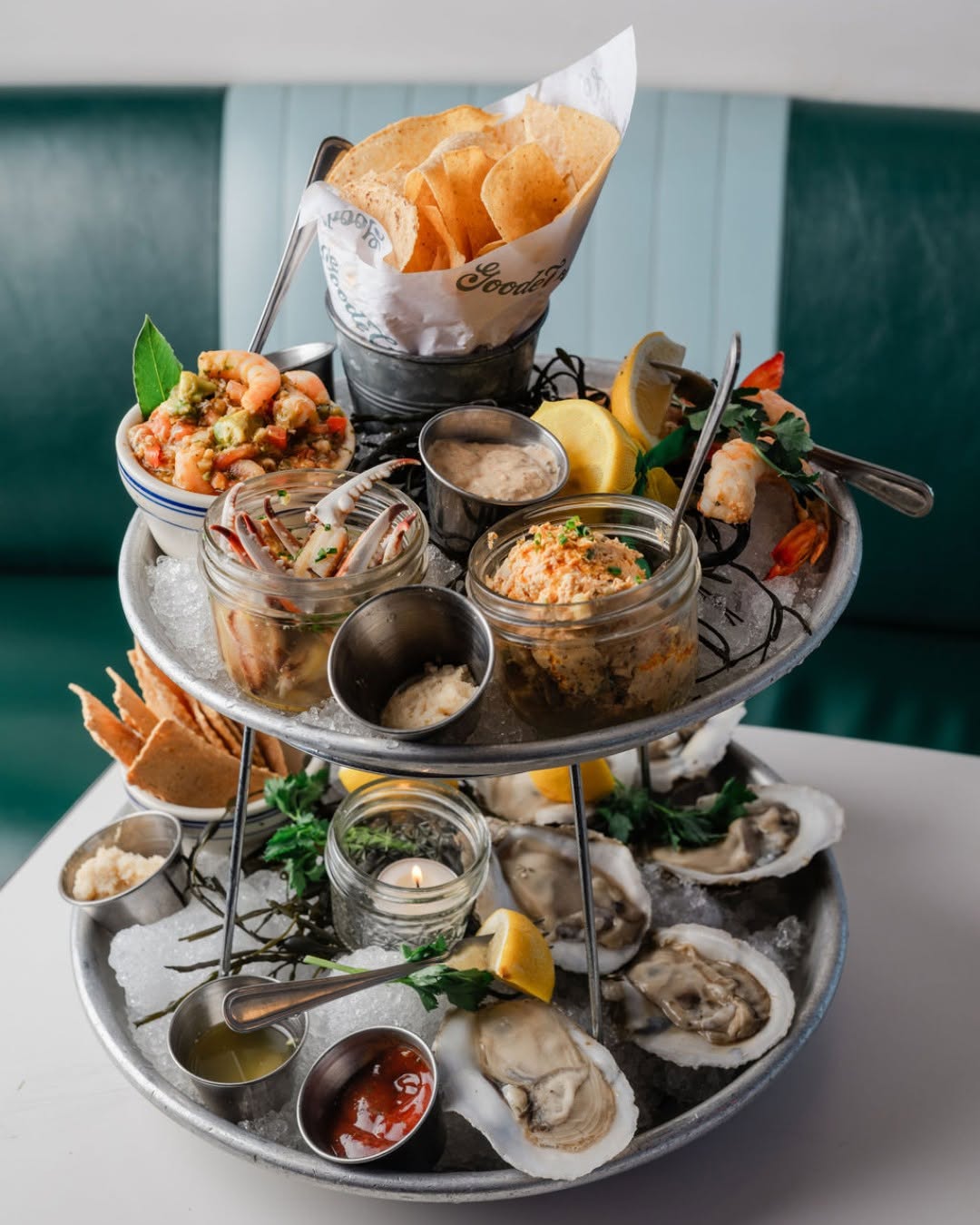 Tiered seafood tower of raw oysters on ice with shrimp cocktail cones from Goode Co. Seafood
