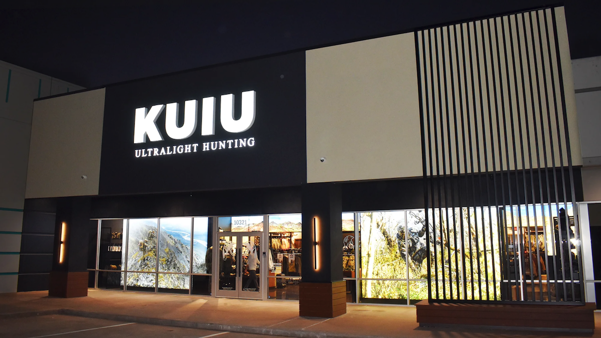 Exterior of the KUIU Ultralight Hunting storefront at Katy Retail Centers at dusk, with a backlit sign on a dark facade