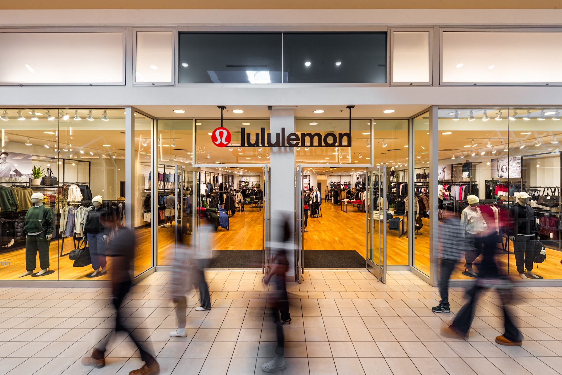 Shoppers passing the lululemon storefront at Memorial City Mall