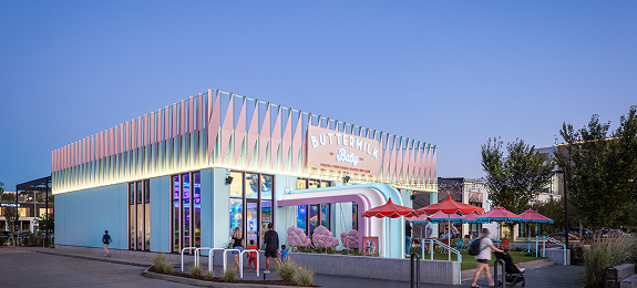 MKT-Discover-Different Exterior of Buttermilk Baby at M-K-T Heights, with its scalloped pastel facade and patio umbrellas