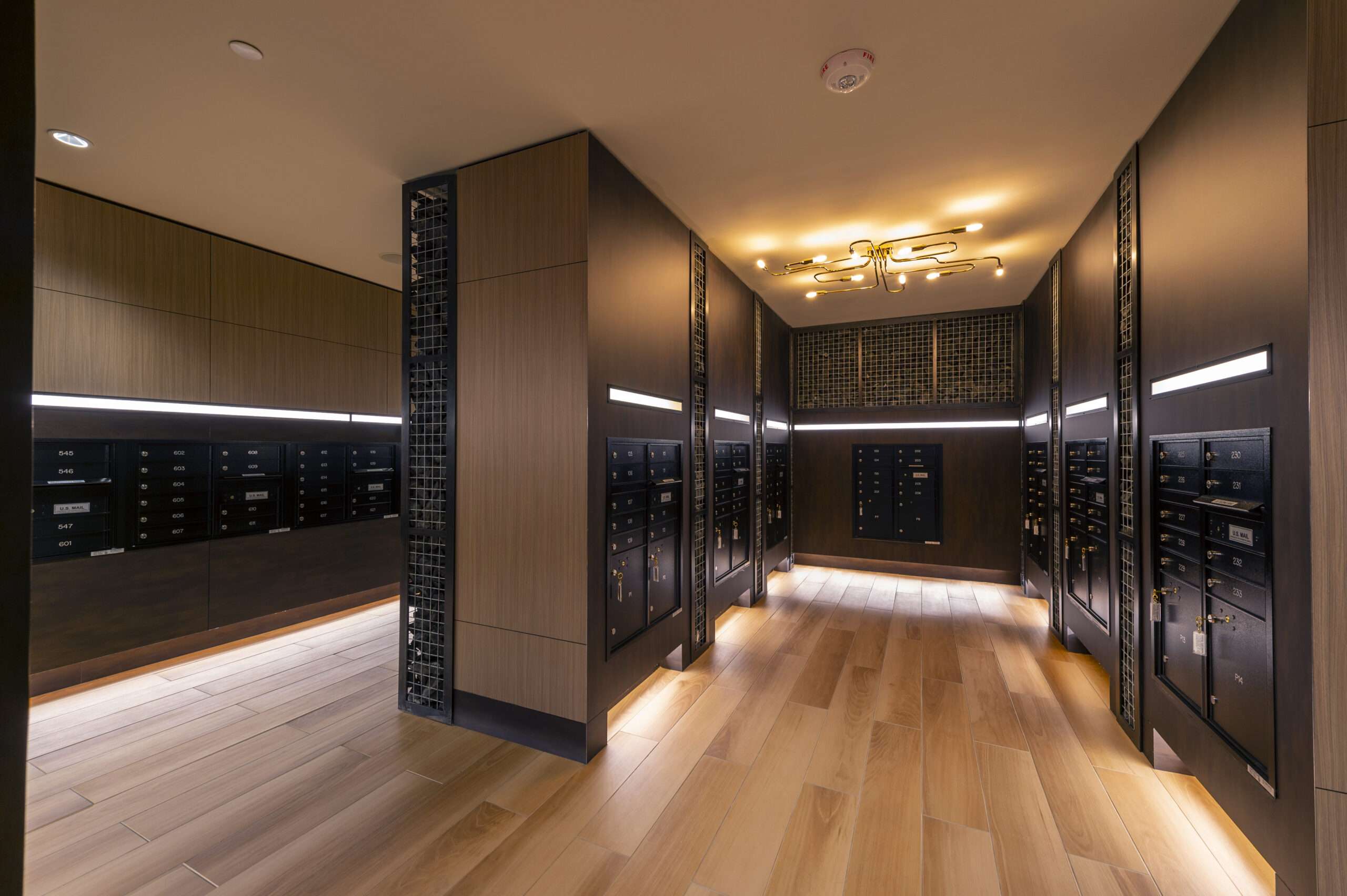 Corridor at The McAdams lined with dark mirrored panels and warm lighting