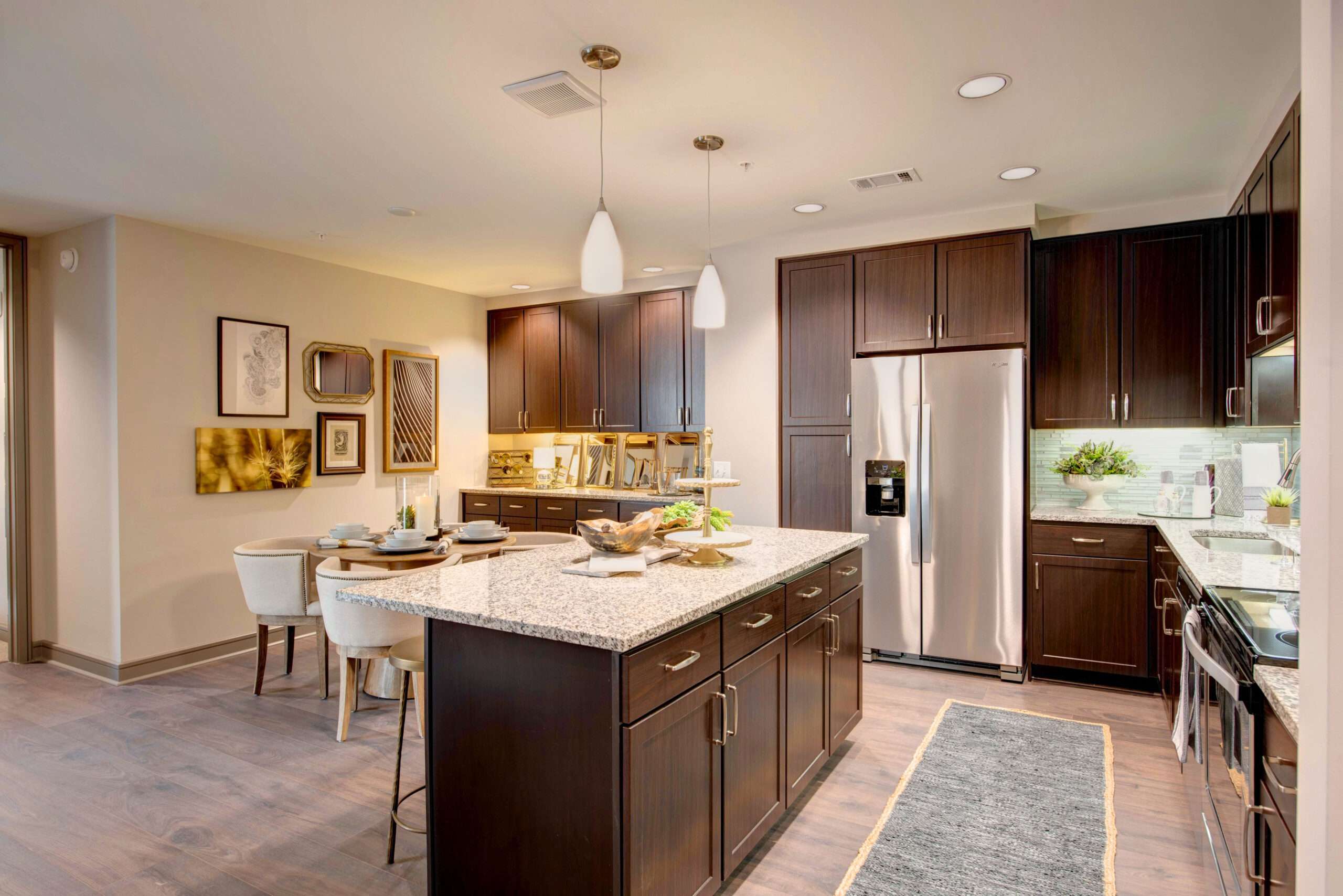 Apartment kitchen at The McAdams with dark cabinets, a island and stainless appliances
