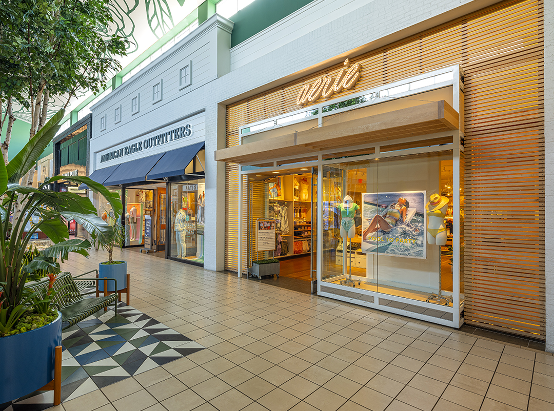 Storefronts and planters along a concourse at Memorial City Mall