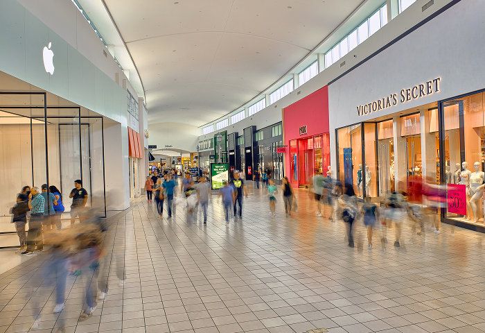 Mem-City-Mall-Overview Shoppers on the concourse at Memorial City Mall, passing the Apple and Victoria’s Secret storefronts