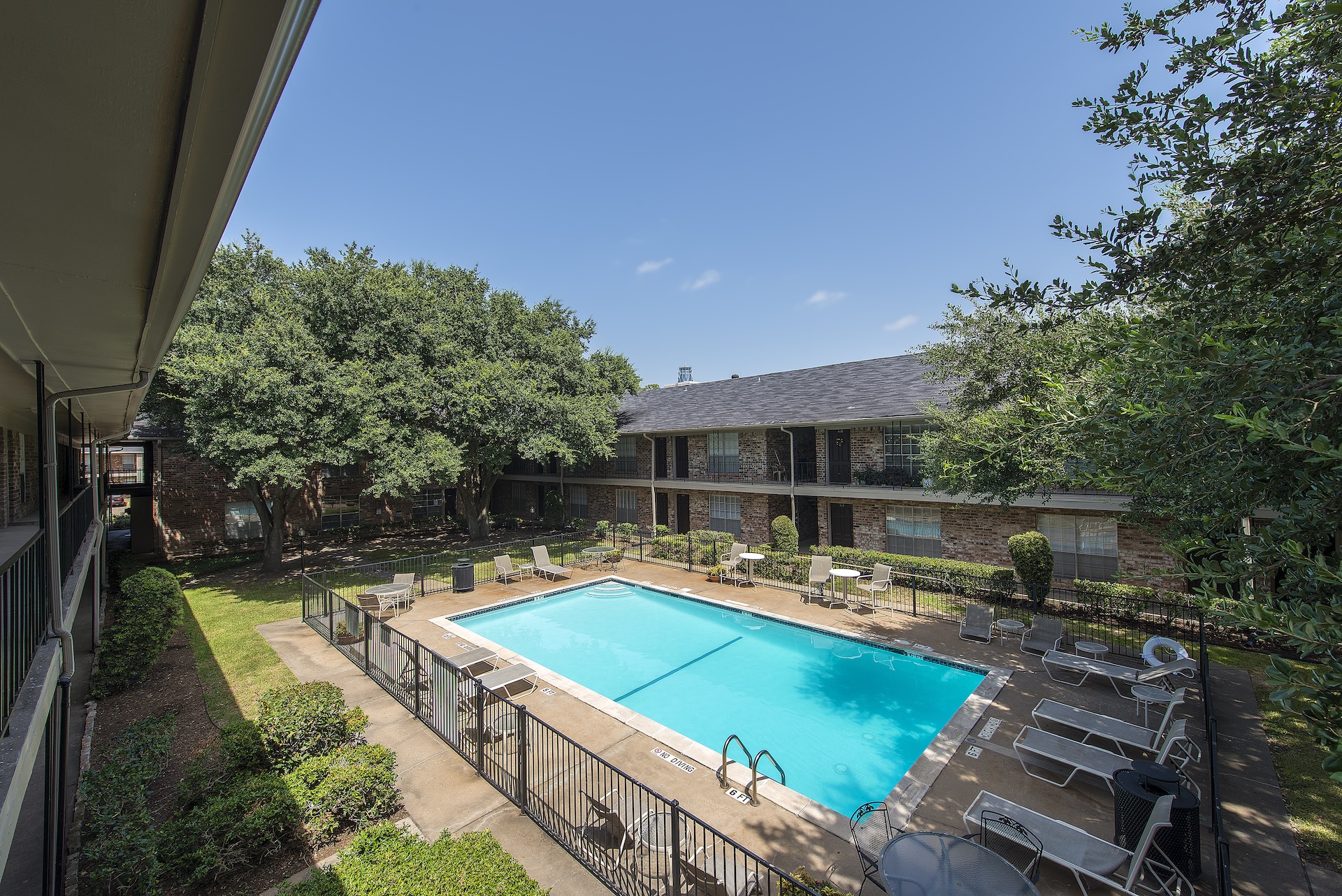 Elevated view of the pool and courtyard at Memorial City Apartments from a resident balcony