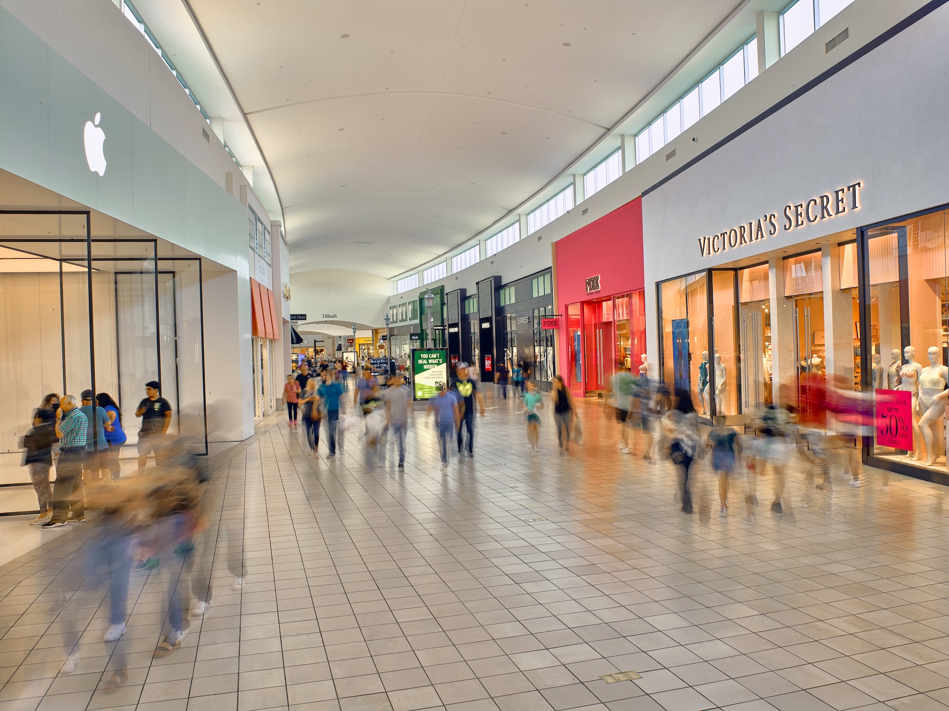 Shoppers walking the concourse at Memorial City Mall past the Apple store