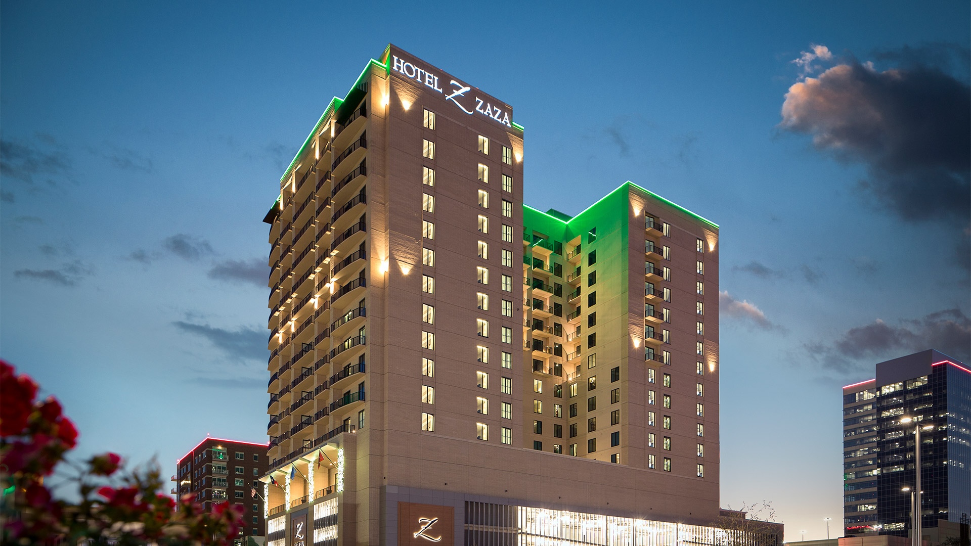 Exterior of Hotel ZaZa Memorial at dusk, with green accent lighting and the Z sign