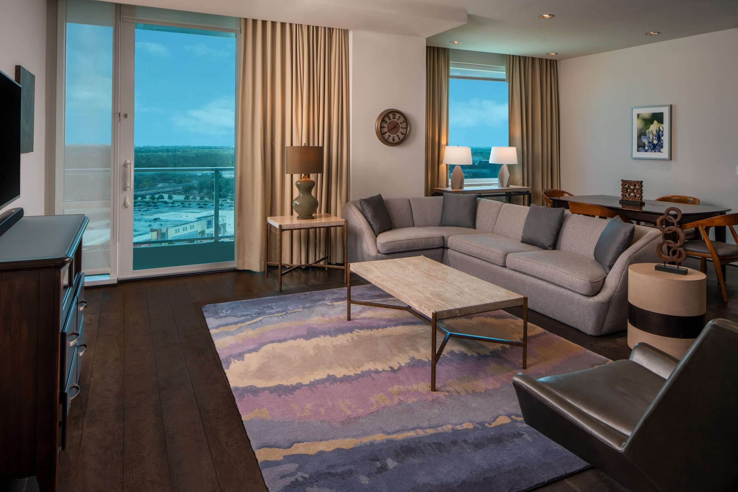 Suite living area at The Westin Memorial with a sofa, armchairs, coffee table and window views