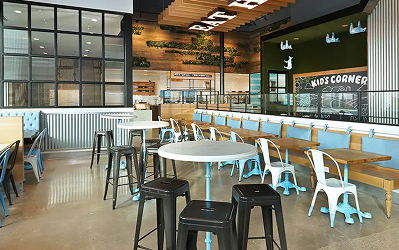 Fast-casual restaurant interior at M-K-T Heights with a service counter and teal metal chairs