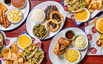 Mia Overhead spread of Tex-Mex plates and side dishes on a red table at Mia’s Table