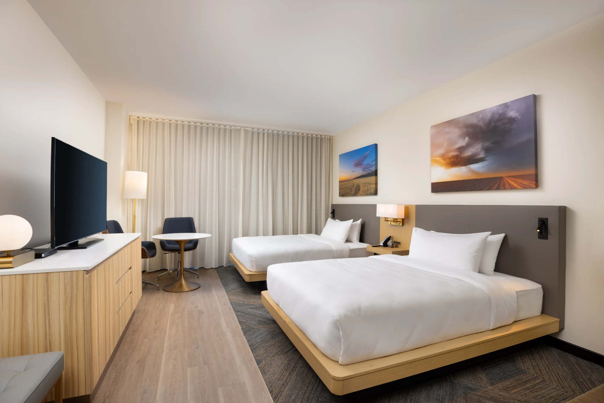 King guest room at The Moran Hotel with a television, work desk and framed landscape artwork