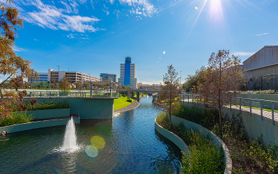 Walking Trail Landscaped waterway with a fountain at Greenside, with office towers rising behind it